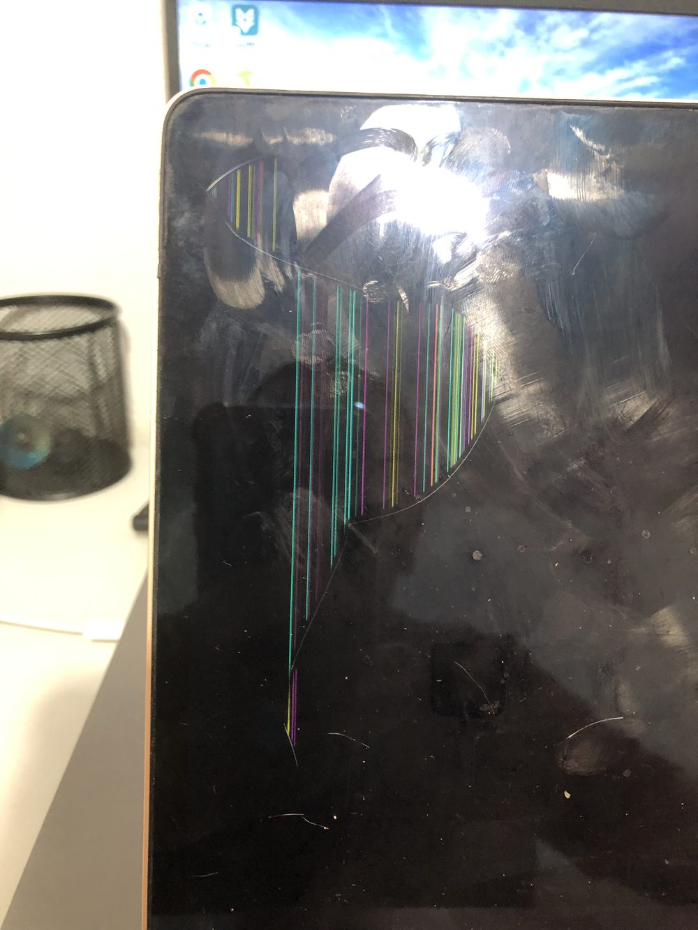 MacBook Air com a tela quebrada e listras